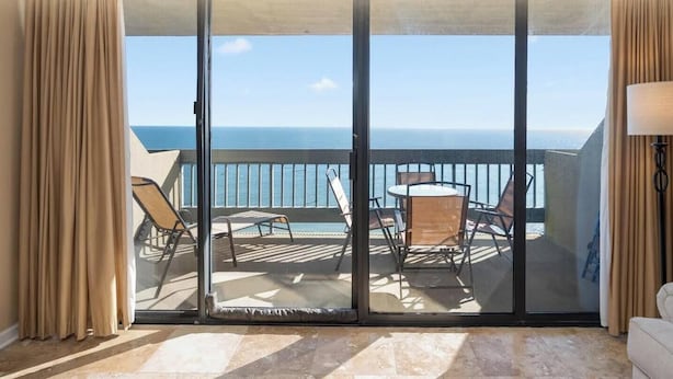 A hotel balcony with a view of the ocean, a table with chairs, and a sofa. - Century One-2 Bedroom Ocean Oasis with Indoor Pool! (Ocean City)