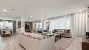 Un salon moderne avec un canapé, une table basse et un coin repas.
