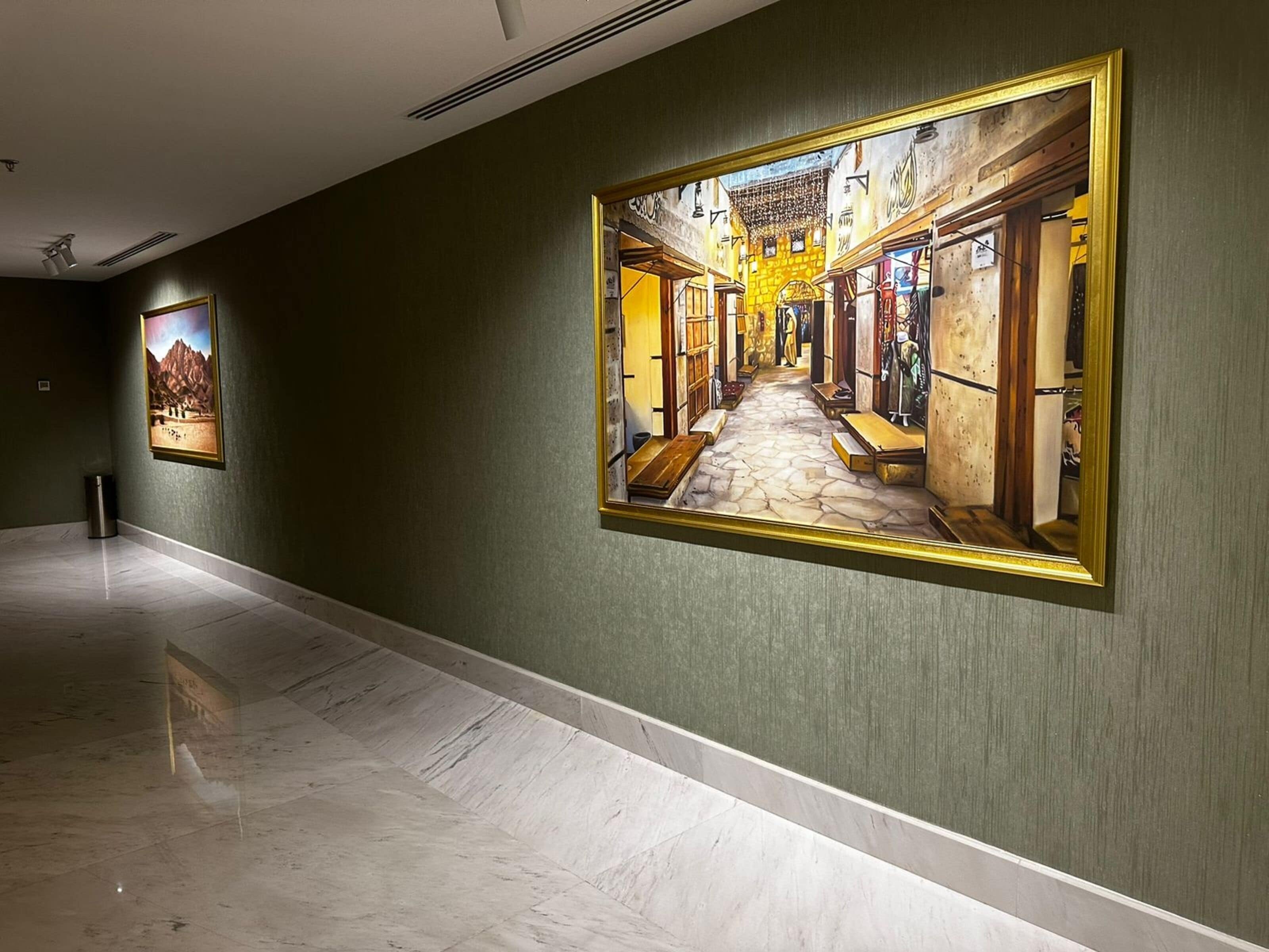 Um corredor com uma grande pintura emoldurada retratando uma cena de rua na parede.