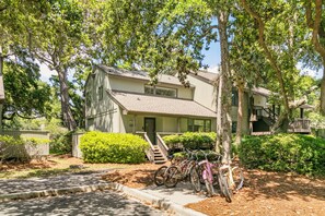 A two-story house with a front porch, a staircase, and a bicycle parked outside. - Updated villa on golf course, 3 min to beach! (Kiawah Island)