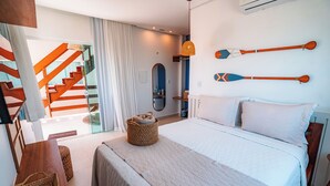 A hotel room with a large bed, a wooden bench, a wicker basket, and a view of a staircase. - POUSADA SOLLARI (Trairi)