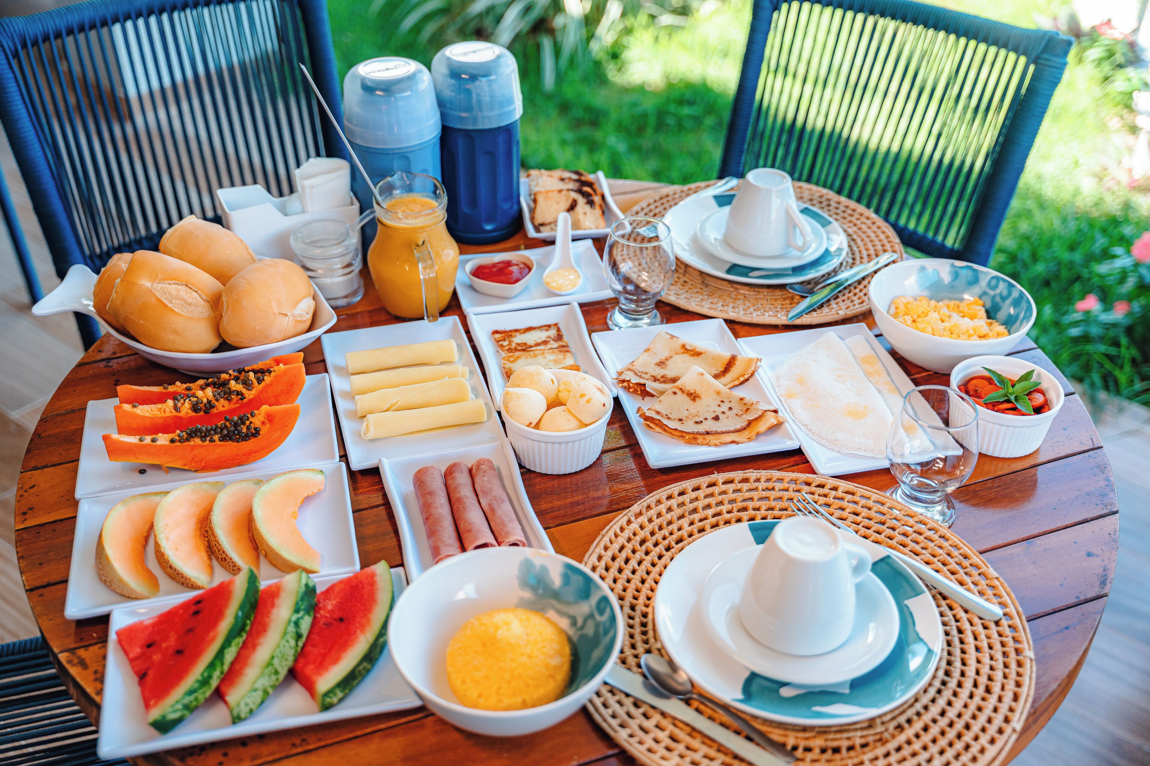 Un bufé de desayuno con diversos alimentos y bebidas sobre una mesa de madera.