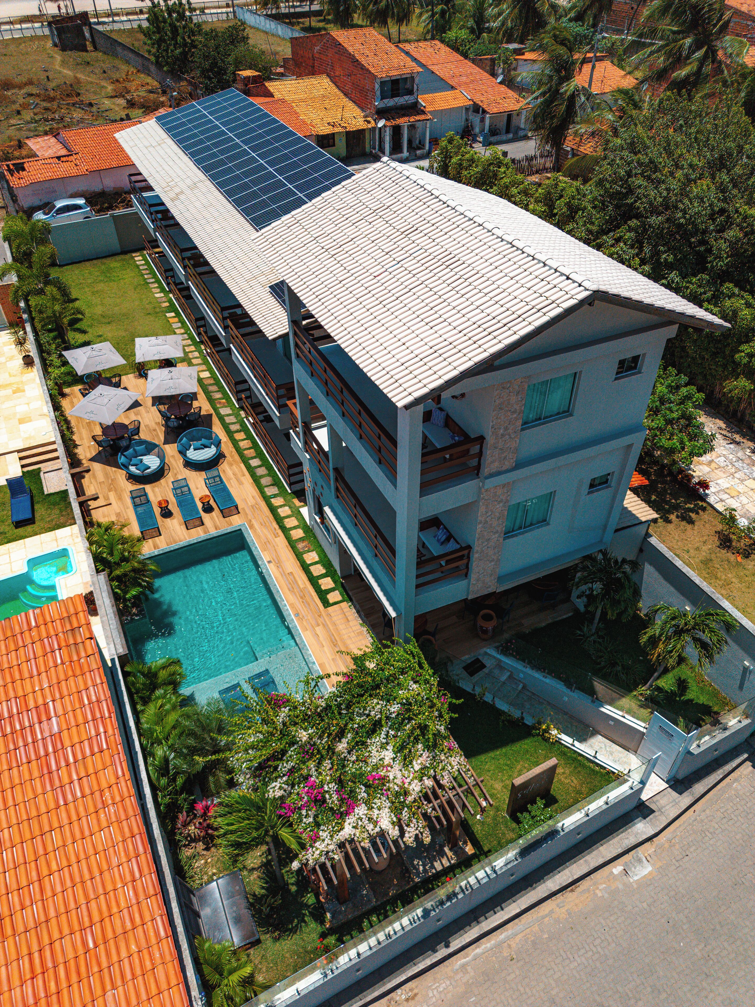 A hotel with a swimming pool, outdoor seating, and a large building with multiple balconies.