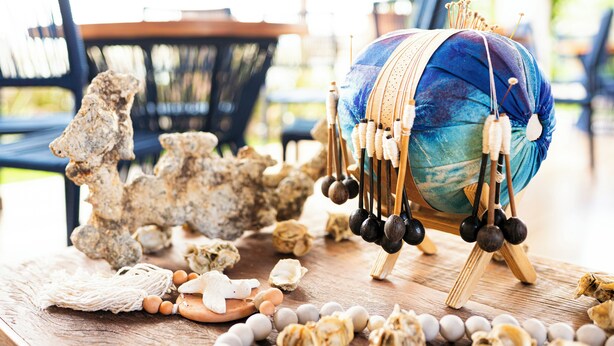 A table with a blue drum, wooden mallets, and various natural objects like shells and stones. - POUSADA SOLLARI (Trairi)
