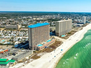 Ein Küstenhotel mit mehreren Etagen, einem Schwimmbad und Blick auf den Strand.