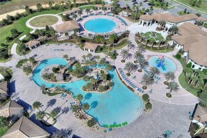 Eine Vogelperspektive zeigt einen luxuriösen Kurort mit mehreren Schwimmbecken, Palmen und Liegebereichen.
