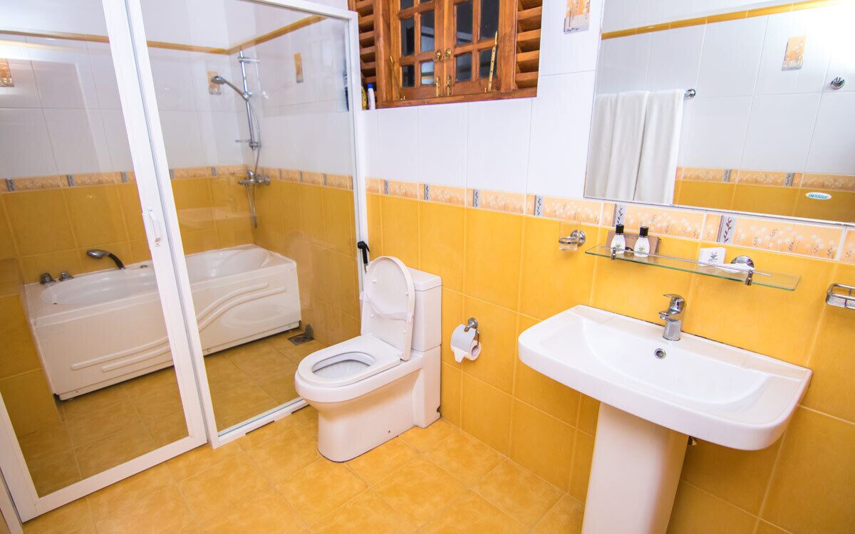 A bathroom with a toilet, a sink, and a shower.