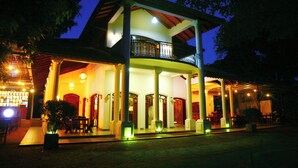 A two-story building with a balcony, columns, and a covered patio area. - Adaviya Resort (Mahiyanganaya)