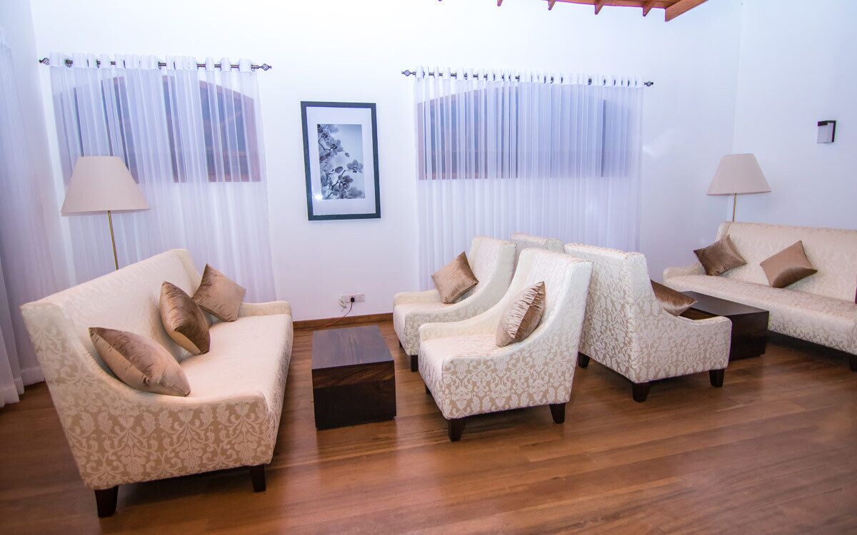 Una sala de estar con un sofá color beige, dos sillones y una mesita de centro.