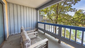 A balcony with a view of trees and a fence. - Beautiful new studio on the water (New Bern)