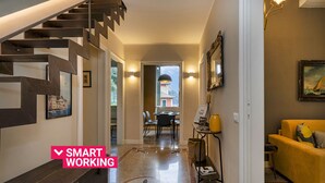 Un interior moderno con una escalera, una zona de comedor y un sofá.