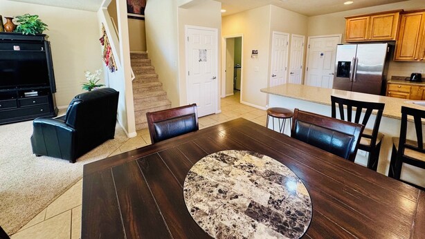 A modern kitchen with a stainless steel refrigerator, wooden cabinets, and a granite countertop. - Palm Paradise by Mesquite Vacation Rentals with Community Pool, Two Primary Suites and $510 in free daily activities (Mesquite)