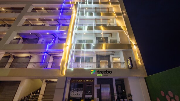 Een meerlaags gebouw met verlichte gevelverlichting en een bedrijfsnaam.