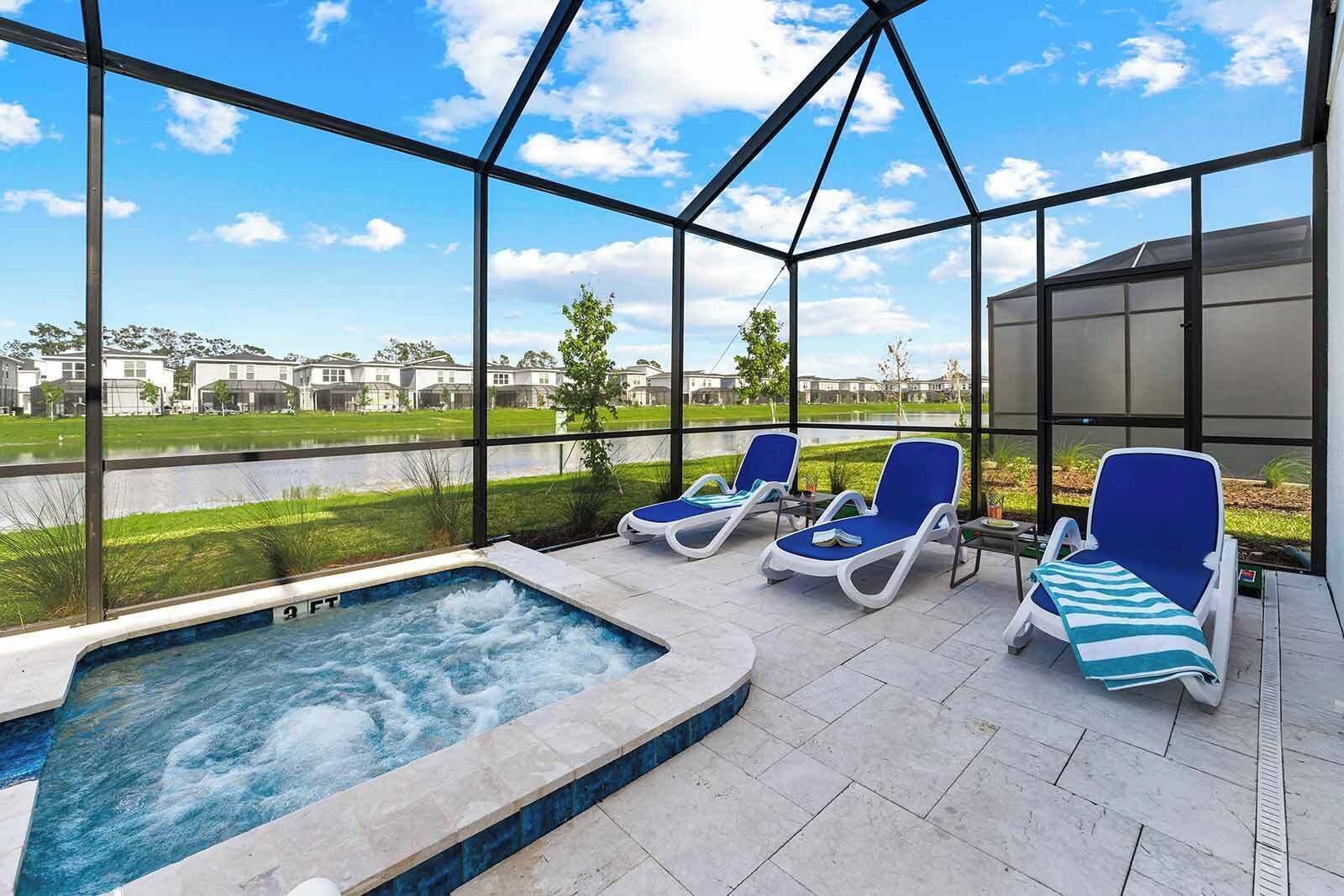 Un espace piscine aménagé sur le toit, avec un jacuzzi, des chaises longues et une vue sur un quartier résidentiel.