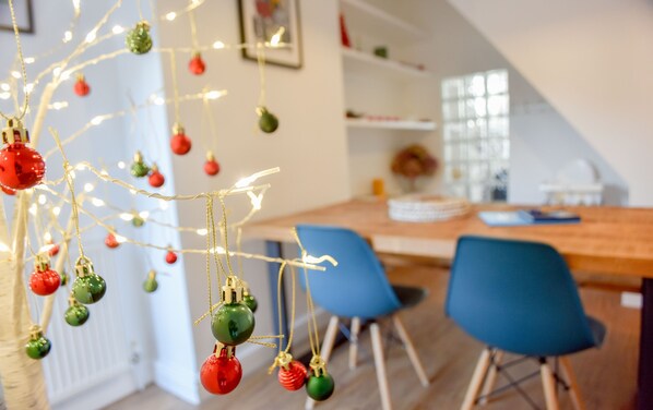 Ein modernes Interieur mit Essbereich, blauen Stühlen und Weihnachtsdekorationen.