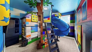 A playroom with colorful walls, a slide, and a ladder.