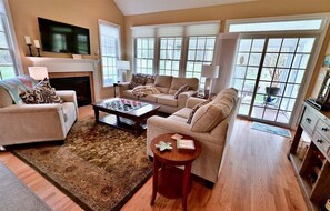 A living room with a fireplace, sofas, a coffee table, and a television. - Bear Trap Dunes Resort Bethany Beach 4BR, 3.5 Bath (Ocean View)