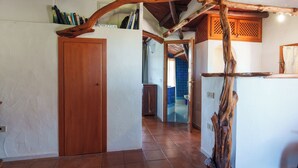 A hallway with a wooden door, a rustic wooden beam, and a tiled floor. - Panoramic Attic with Pool | Near Costa Smeralda (Olbia)