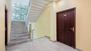 A staircase leading to a landing with a dark wooden door marked with the number 201. - Treebo Saffron (Lucknow)