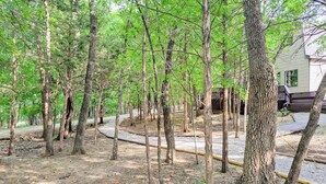 Zona boscosa con un sendero de tierra y una estructura de madera.