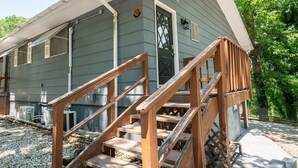 A two-story house with a wooden staircase leading to the front door. - Tribesman Resort #10 - Renovated Condo, Mins to Silver Dollar, Great Location! (Branson)