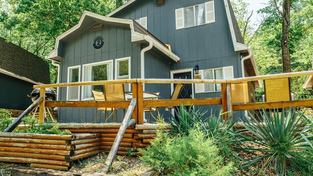 A cabin with a wooden deck and a small porch area. - Tribesman Resort #2 - Renovated Cabin, Minutes to Silver Dollar, Great Location! (Branson)