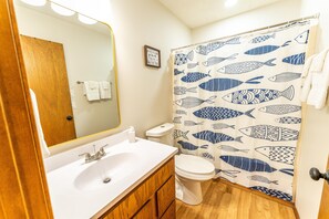 A bathroom with a wooden vanity, white sink, and toilet. - Tribesman Resort #21 - Renovated Cabin, Minutes to Silver Dollar, Great Location (Branson)