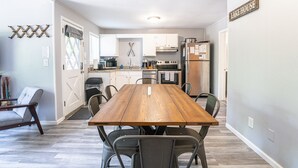 A compact kitchen with white cabinets, a stainless steel refrigerator, and a microwave. - Tribesman Resort #5 - Renovated Cabin, Minutes to Silver Dollar, Great Location! (Branson)
