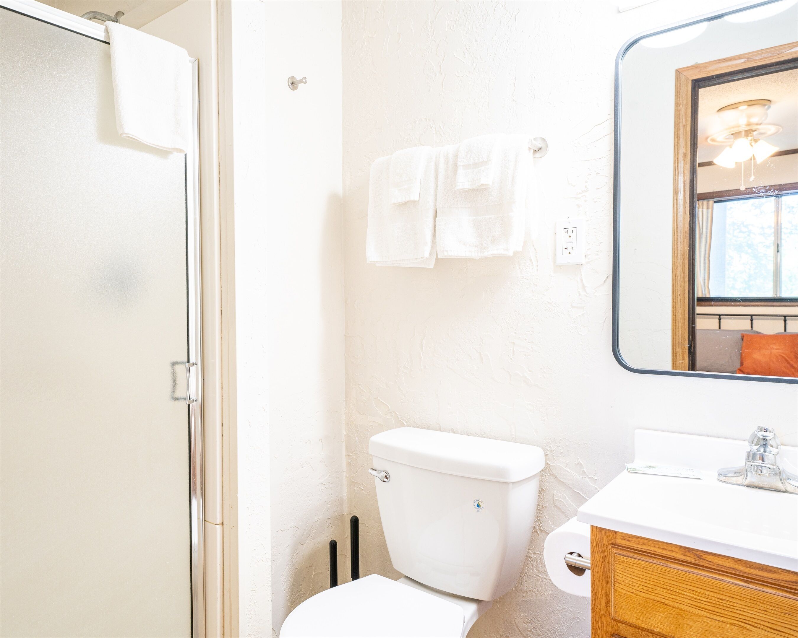 Une salle de bain équipée de toilettes, d’un lavabo et d’un miroir.