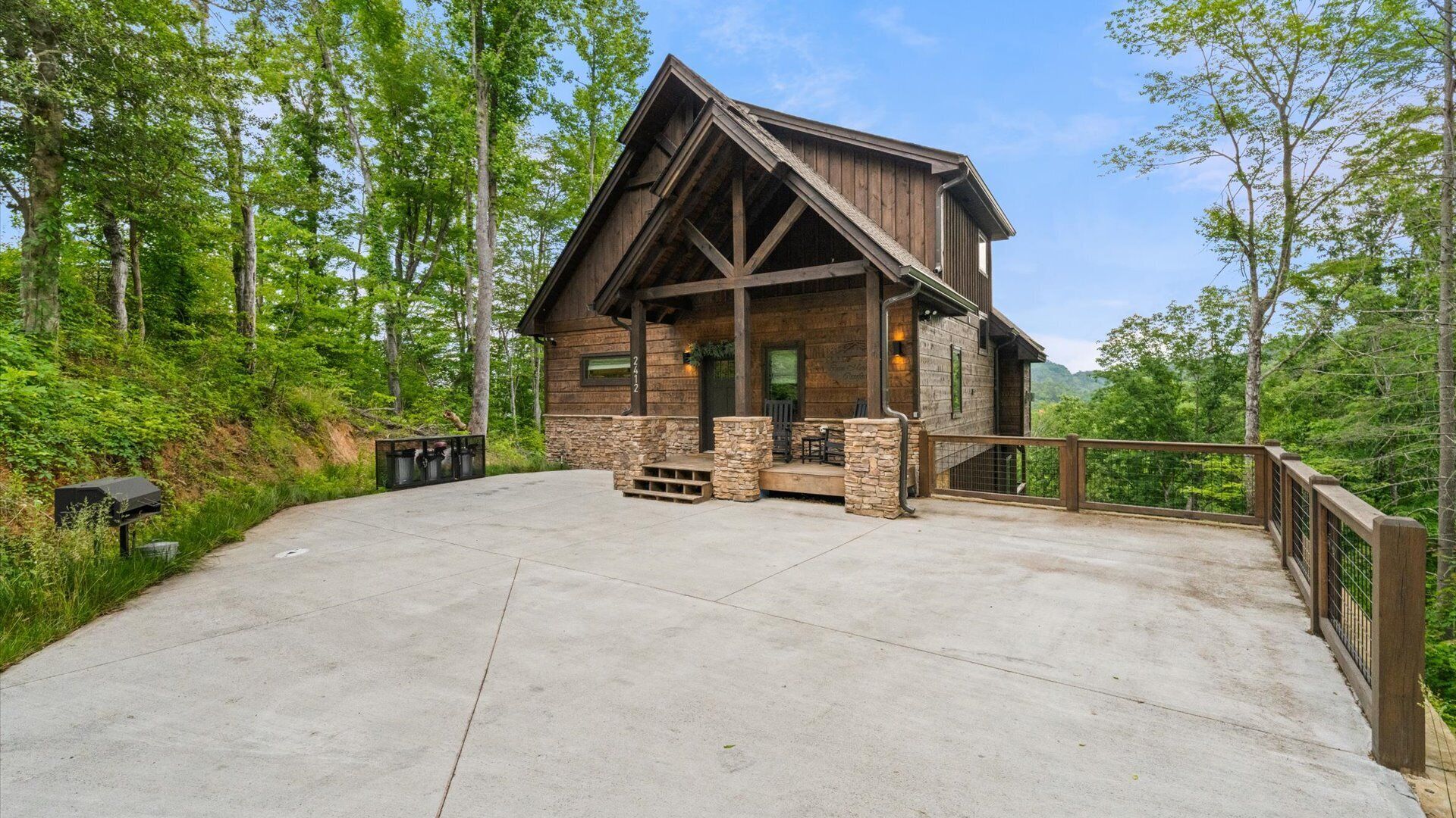 A rustic lodge with a stone foundation, wooden beams, and a covered porch.