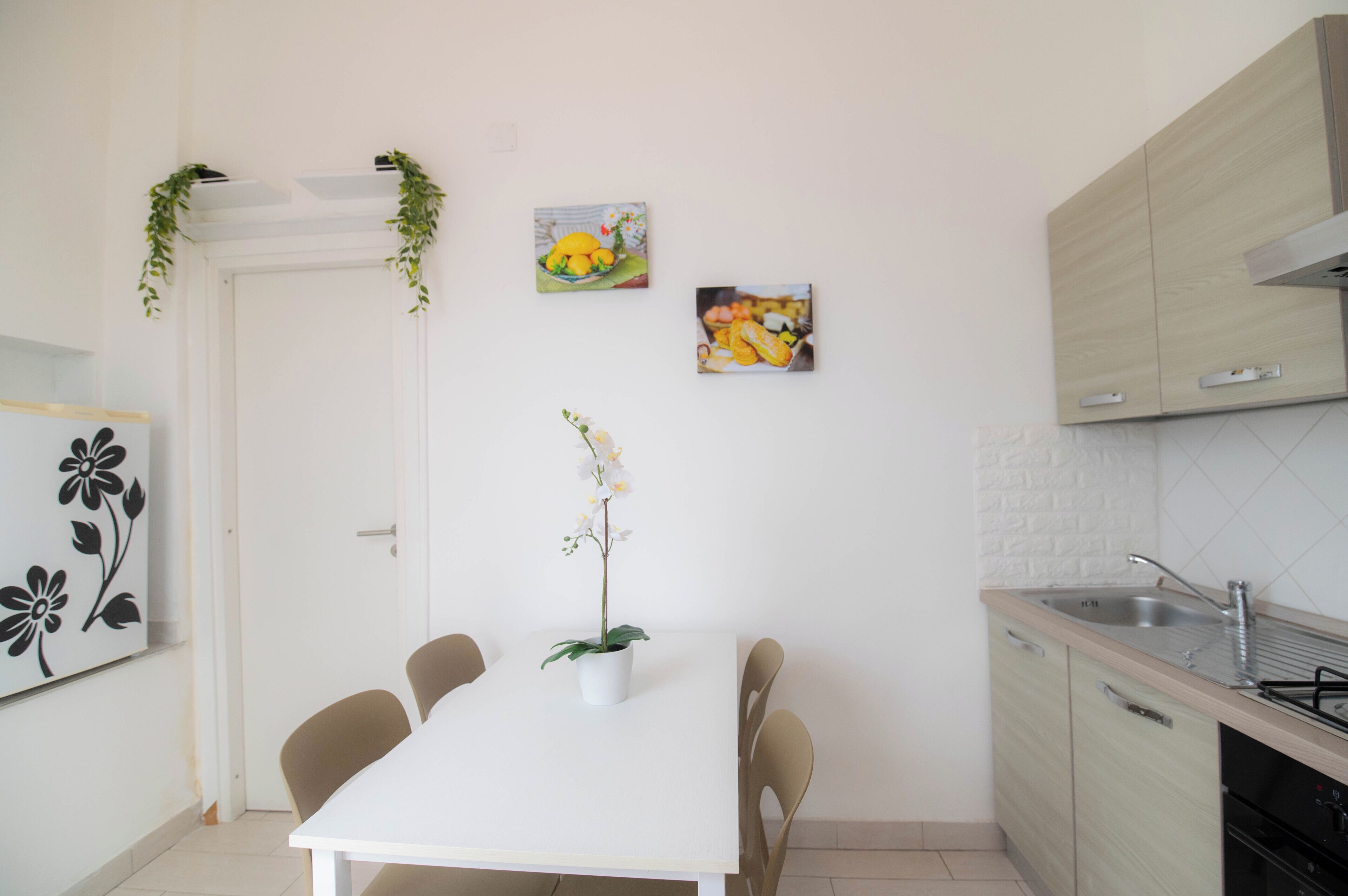 Une cuisine moderne avec une table blanche, des chaises et un évier.