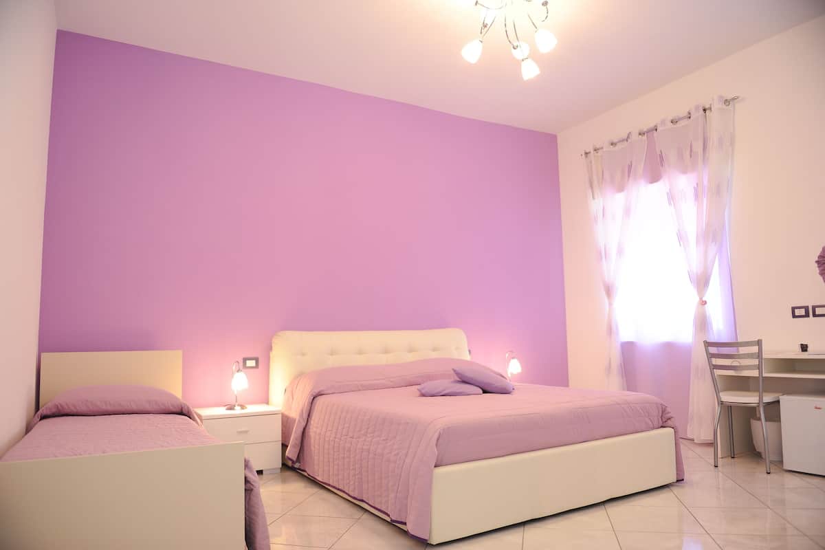 A bedroom with a bed, a desk, and a chair.