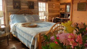 Een rustieke kamer met houten vloer, een bed, een bureau en een stoel.