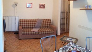 A living room with a checkered sofa, a small table with a basket, a radiator, and a wall-mounted shelf with cups. - Casa Greta 5 minutes walk from the beautiful beaches and cycle path.
Balcony (Arma di Taggia)