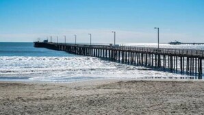 Un muelle que se adentra en el océano bajo un cielo despejado.