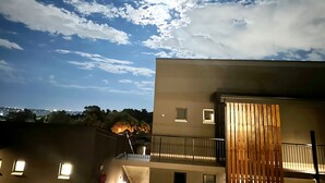 Un immeuble doté d’un balcon et offrant une vue sur le ciel et les nuages.