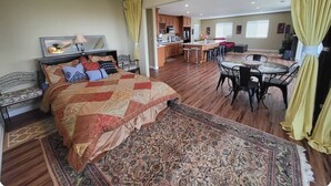 Una habitación amplia con una cama grande, un comedor y una cocina.