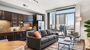 A modern apartment with a kitchen, living area, and large windows offering a city view. - Austin Comfortable 1BD 1BA Apartment (Austin)