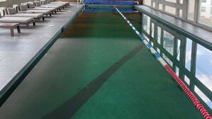 A swimming pool with a long bench seating area on one side and a wooden wall on the other. - Amazing studio in Condesa (Ciudad de México)