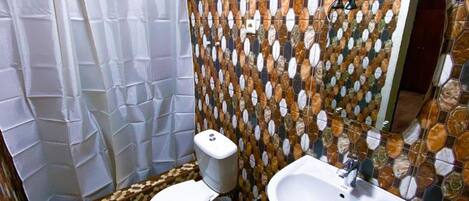 A bathroom with a toilet, sink, and shower curtain.
