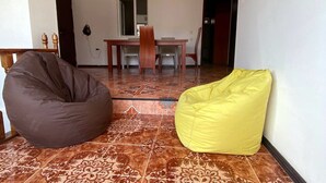 A room with a patterned tile floor, a dining table with chairs, and two bean bags. - Good Night (Tbilisi)