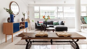 Un salon moderne avec une table basse en bois, un canapé et un buffet agrémenté d’objets décoratifs.