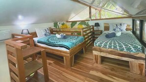 Een kamer met twee houten bedden, een houten tafel en een plafond met dakramen.