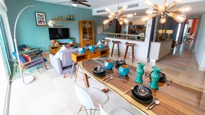 A modern living room with a dining area, a kitchen, and a ceiling fan. - Via 38 A13 - Modern Condo - At Via 38 (Playa del Carmen)