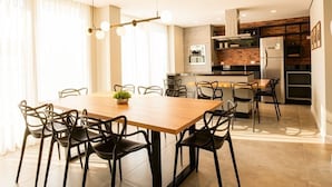 A modern kitchen with a central island, built-in appliances, and a dining area with a wooden table and chairs.