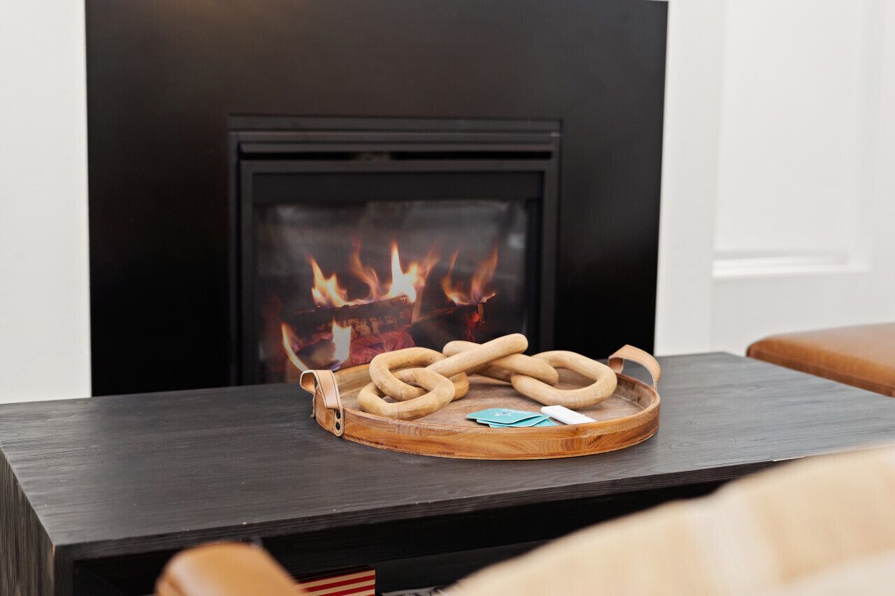 Ein Kamin mit einer Holztablett, auf dem Hoses aufgewickelt sind.