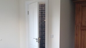 A bedroom with a bed, a wardrobe, and a door leading to a bathroom.