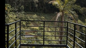 A wooden deck with a metal railing overlooking a lush forested area. - Gaia glamping  (San Rafael)