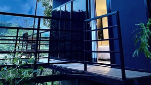 A modern building with a large glass window and a door leading to an interior space. - Gaia glamping  (San Rafael)
