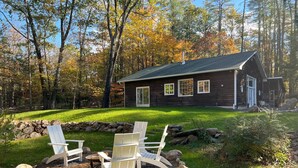 A cabin with a stone fire pit and two white Adirondack chairs. - THE HIDDEN COTTAGE Private, Relaxing, Great Location, Has Everything You Need (Saugerties)